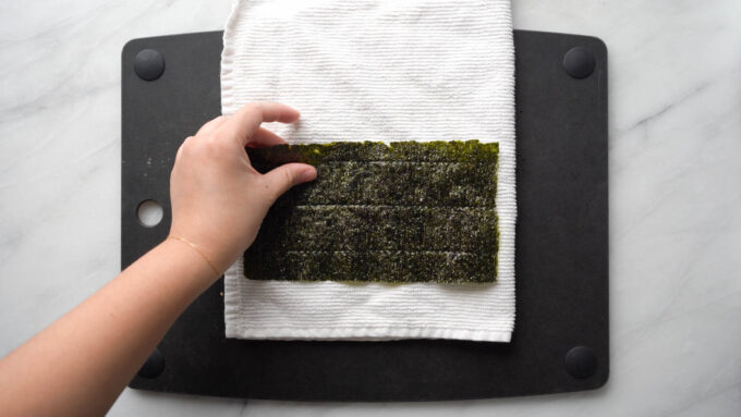 placing half nori sheet on towel