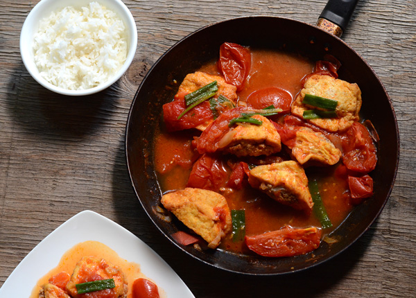 Close-up of fried, pork-stuffed tofu in a tomato sauce () | HungryHuy.com