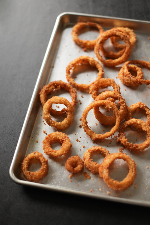 fried onion rings resting on a half sheet