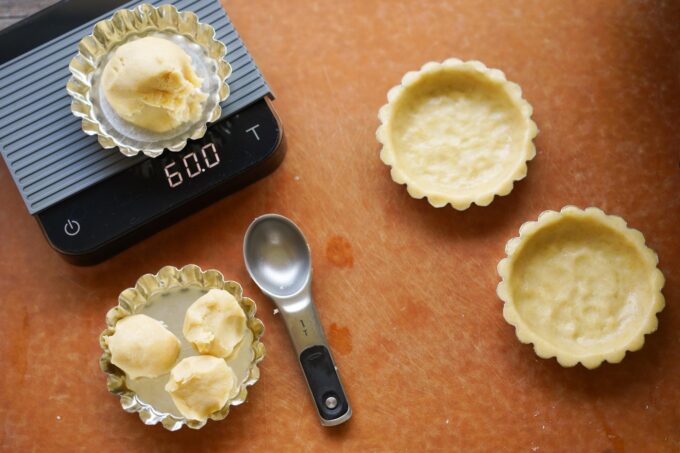 weighing out dough and forming around tart molds