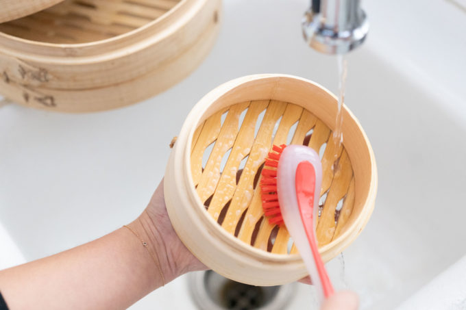 scrubbing bamboo steamer with soapy water