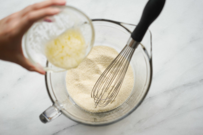 adding butter to sugar to cream it
