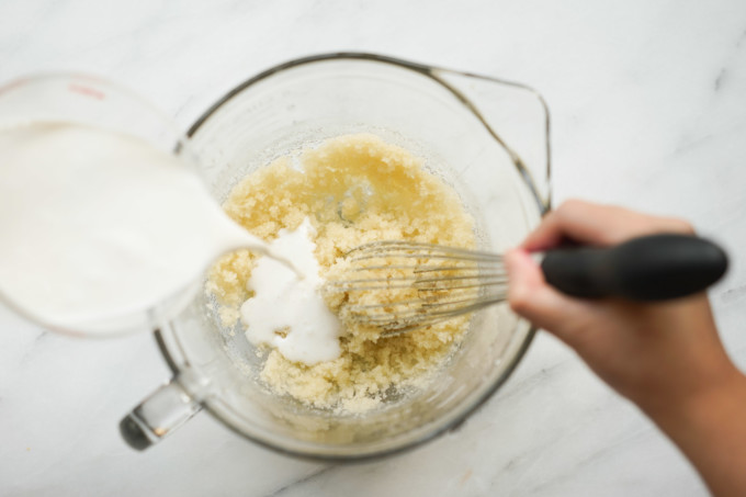 pouring milks into creamed butter