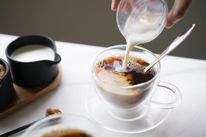 pouring milk into black tea