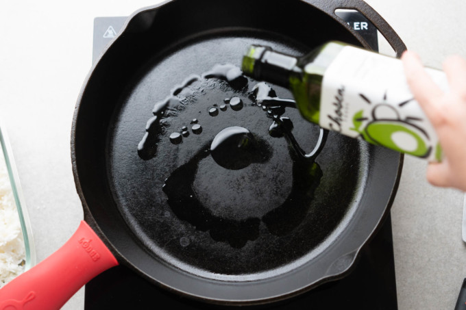 adding oil to cast iron pan