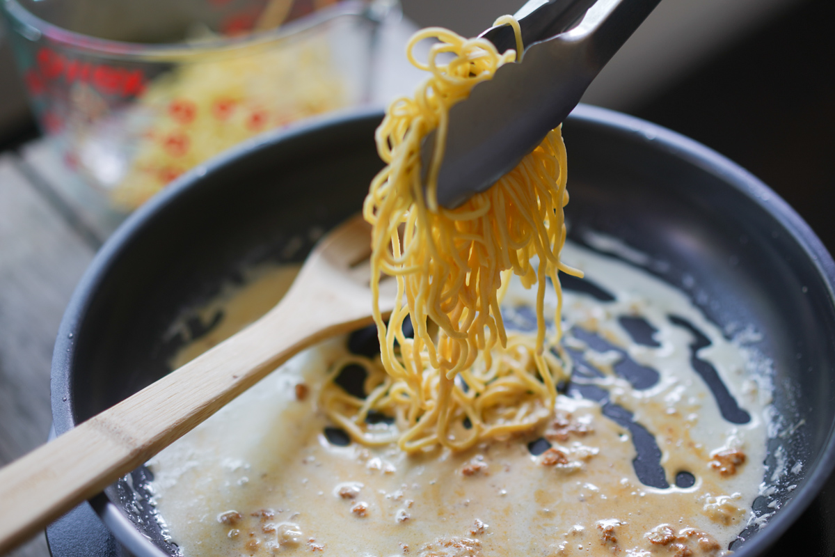 adding homemade pasta to the pan