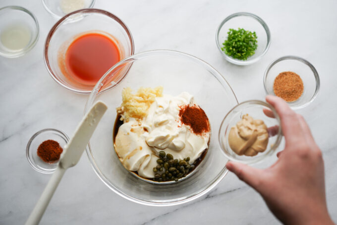 adding mustard to mixing bowl