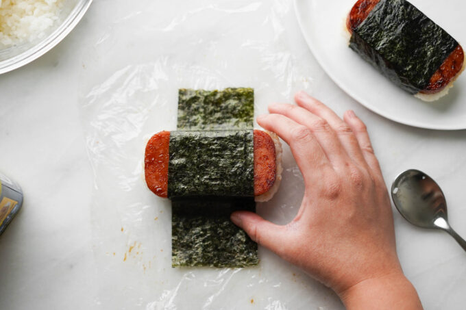 adding seaweed to wrap musubi