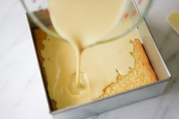 pouring custard topping onto the cake