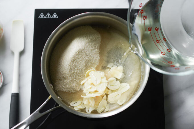 pouring vinegar into a pot of brine ingredients