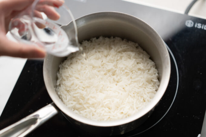 pouring water into pot of rice