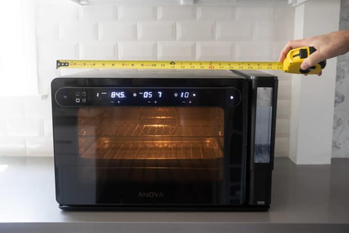 measuring the oven with measuring tape