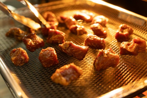 placing marinated steak bites on air fryer basket