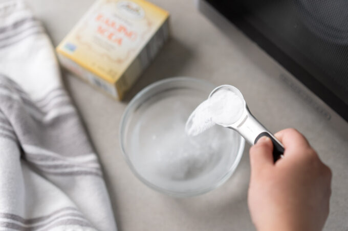 pouring baking soda into water bowl