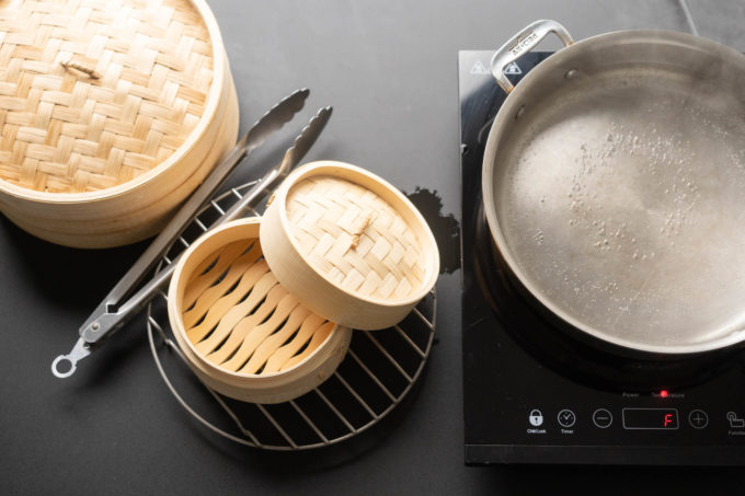 bamboo steamer, tongs, saute pan and induction stove