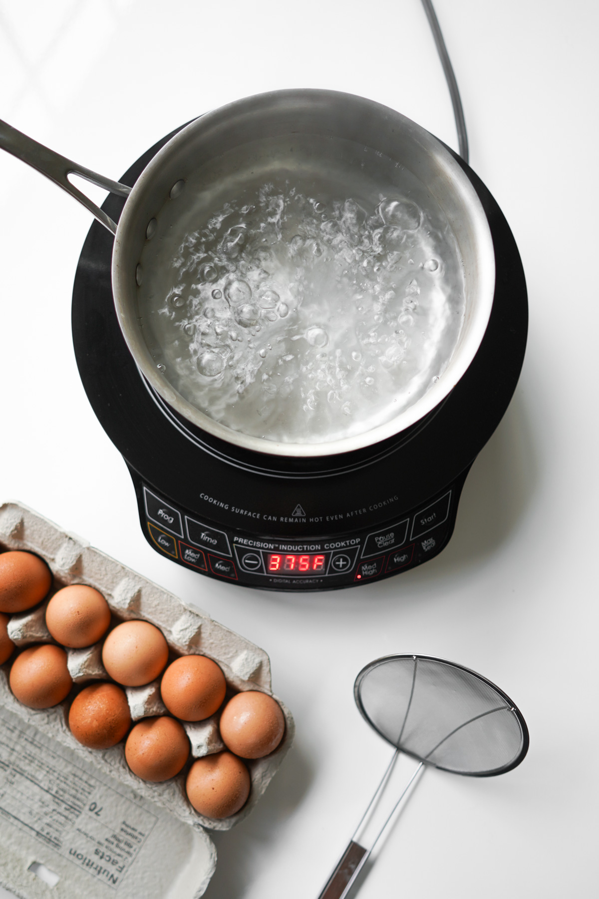 boiling water with a dozen eggs nearby