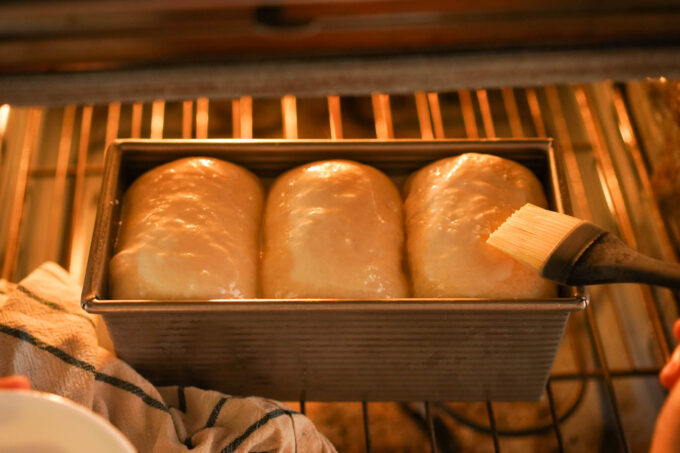 brushing rolls of dough with milk