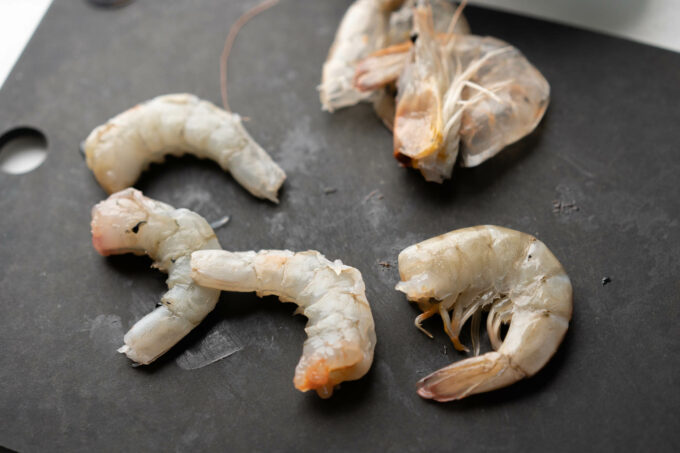 headless peeled shrimp on cutting board