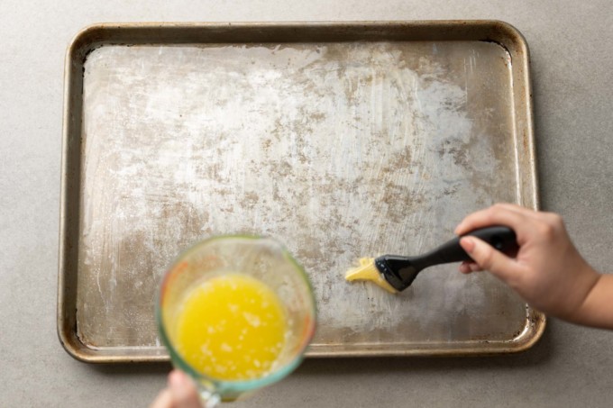 brushing butter on sheet pan