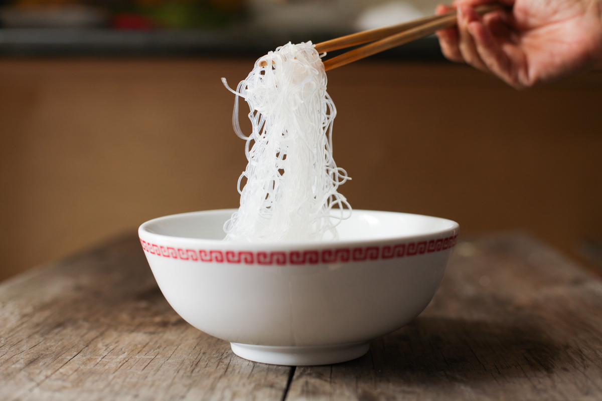 noodle lift! showing the glass noodles / cellophane noodles / mung bean thread, lifted with wooden chopsticks