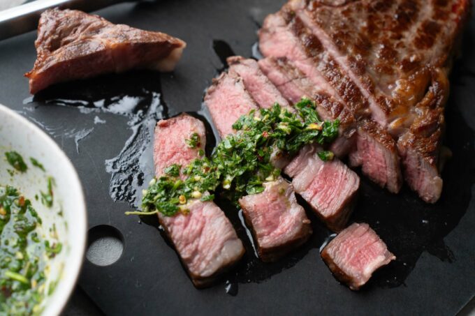 chimichurri sauce on sliced ribeye steak
