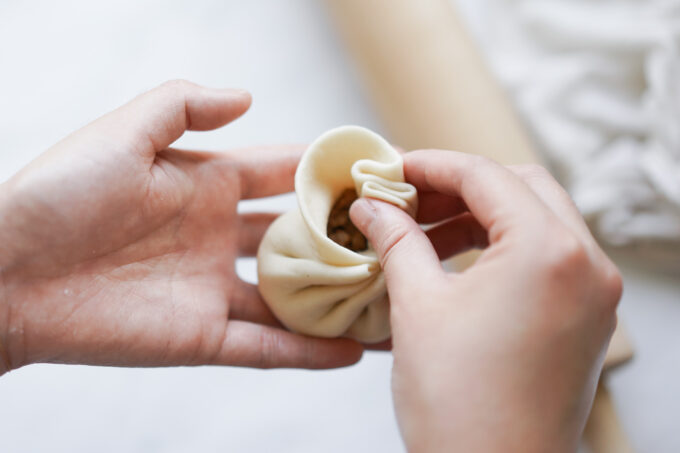 close up of folding bao dough