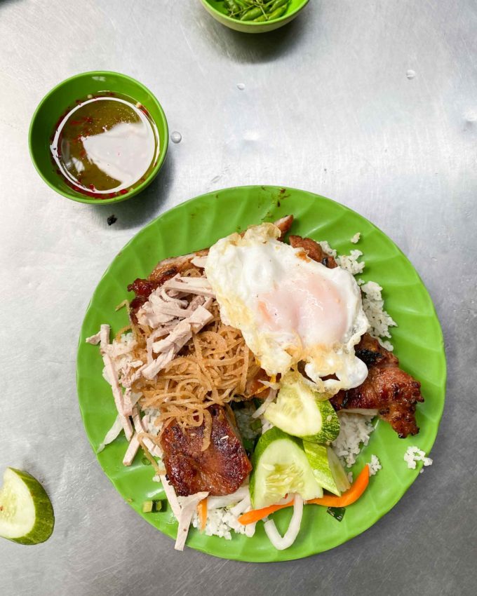 plate of broken rice with shredded pork, pork chop, fried egg