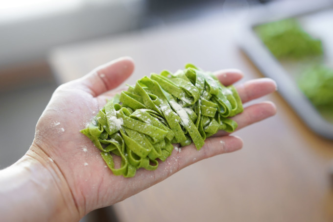 cut spinach pasta with a dusting of flour