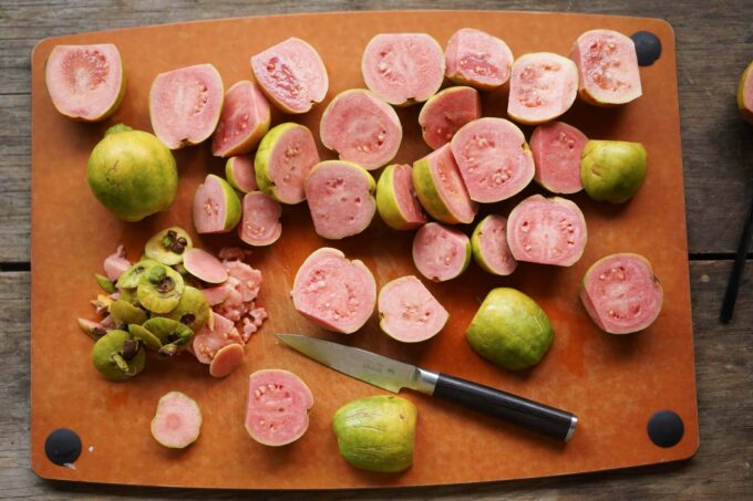 cutting guava in half, removing stems