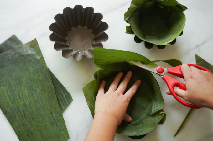 cutting banana leaves to fit molds