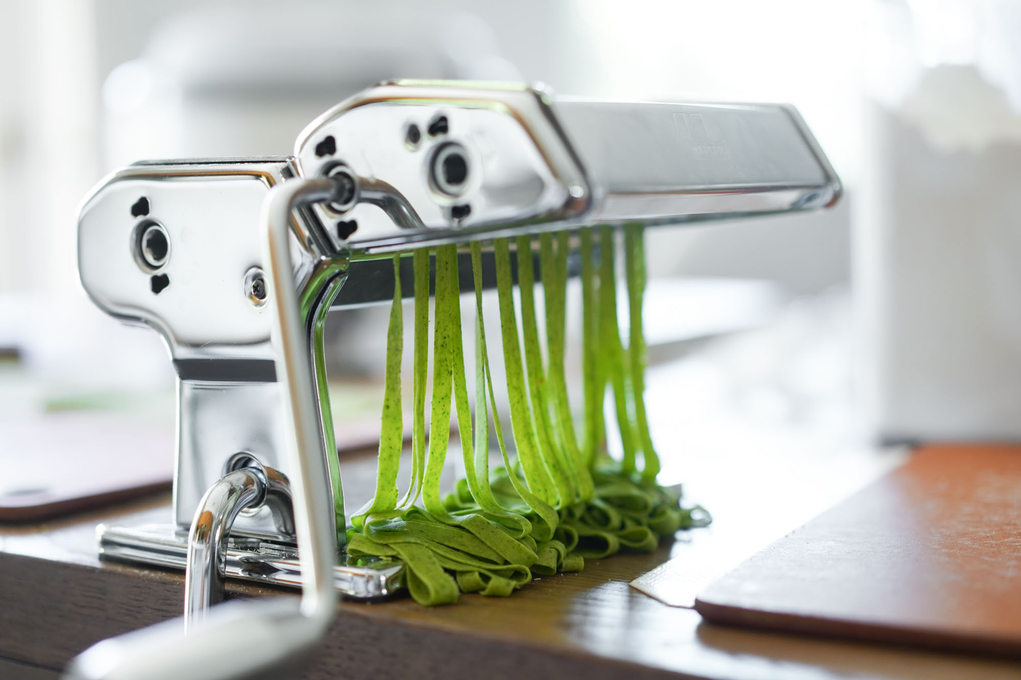 cutting spinach pasta in a pasta machine