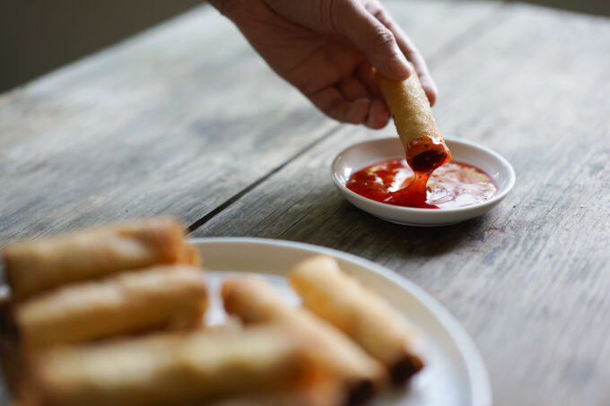 dipping lumpia in La Choy sweet and sour sauce