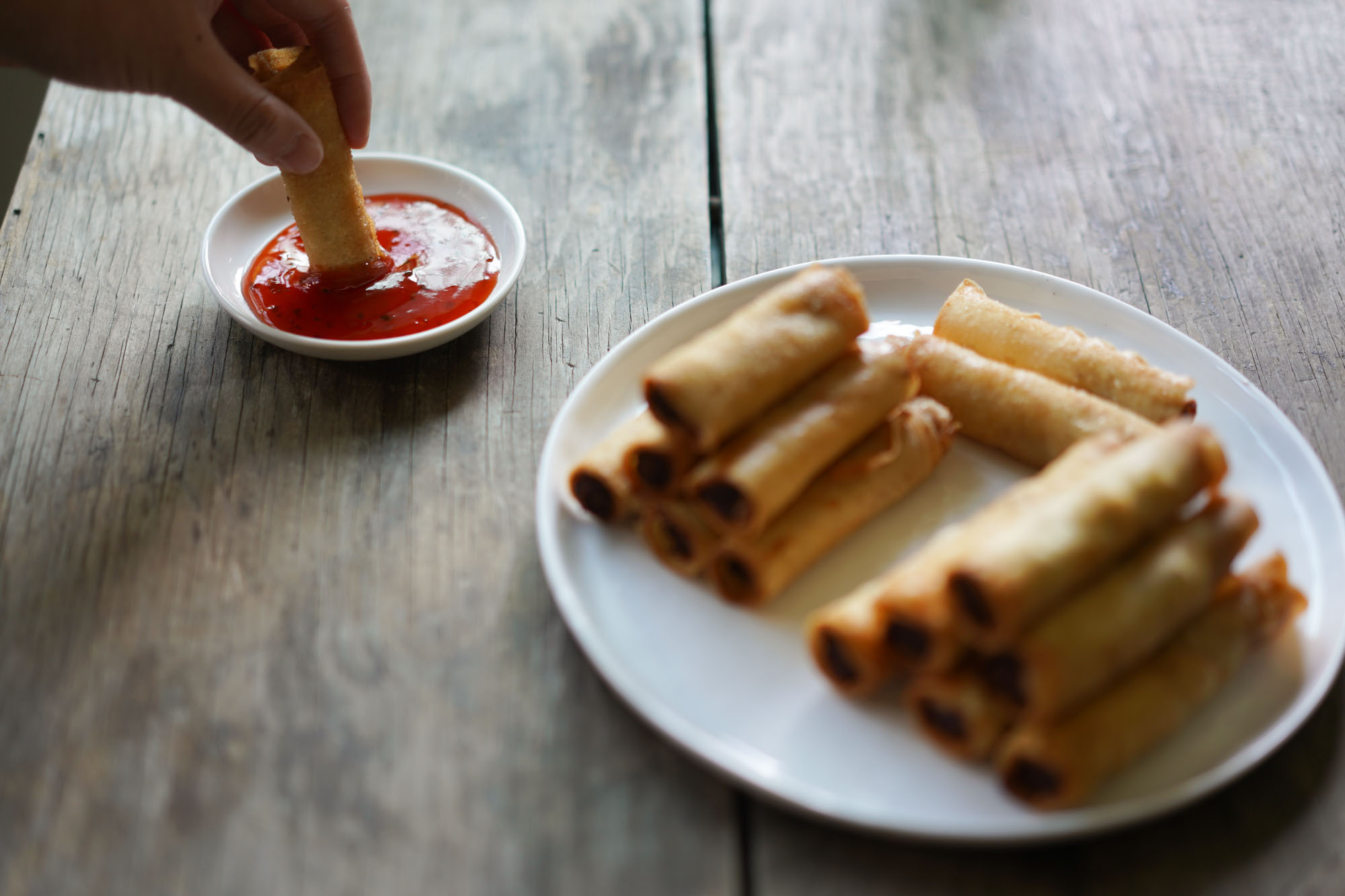 dipping lumpia shanghai into sauce