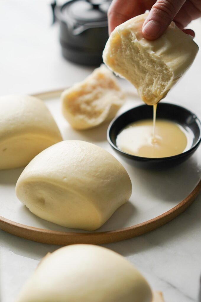 mantou buns dipping into condensed milk