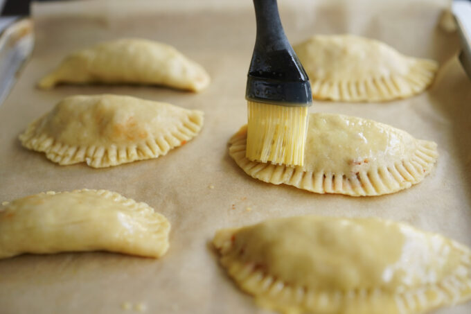 brushing empanadas with egg wash