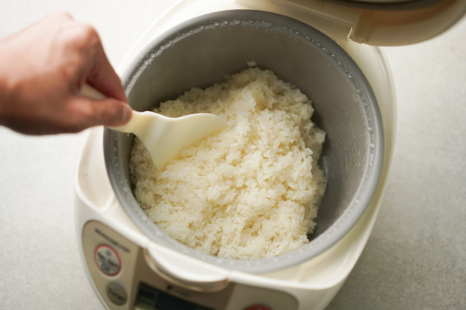 fluffing up sticky rice in a rice cooker