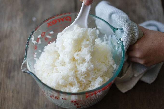 fluffing rice with a paddle before serving