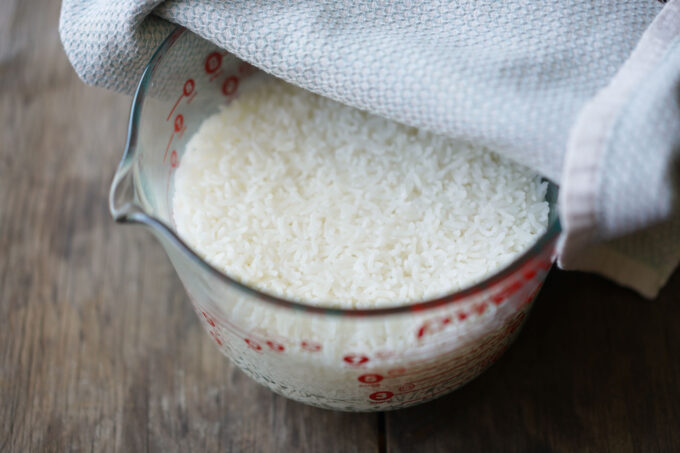 lifting towel to check cooked rice