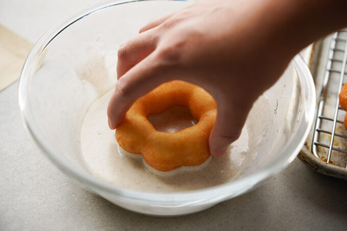 dipping donut in glaze