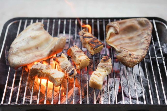 grilling pork over charcoal