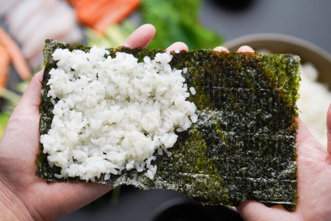 adding rice to nori sheet for temaki / hand roll