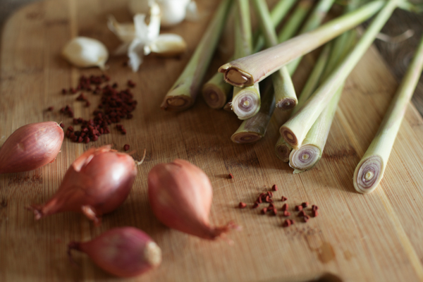 Nồi nước dùng bún bò Huế đang sôi nhẹ với sả, ớt và xương bò trong bếp quán sáng sớm