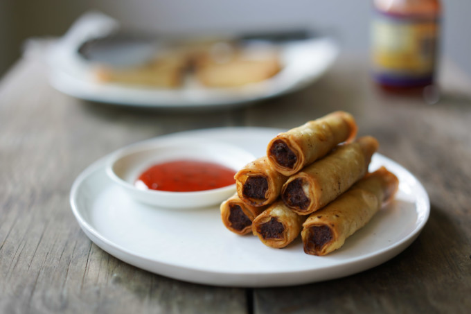 closeup of a tower of lumpia and sweet and sour sauce