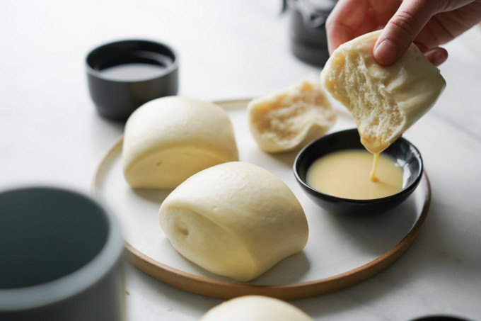 mantou buns dipping into condensed milk