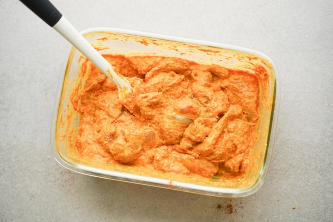 butter chicken marinating in a container