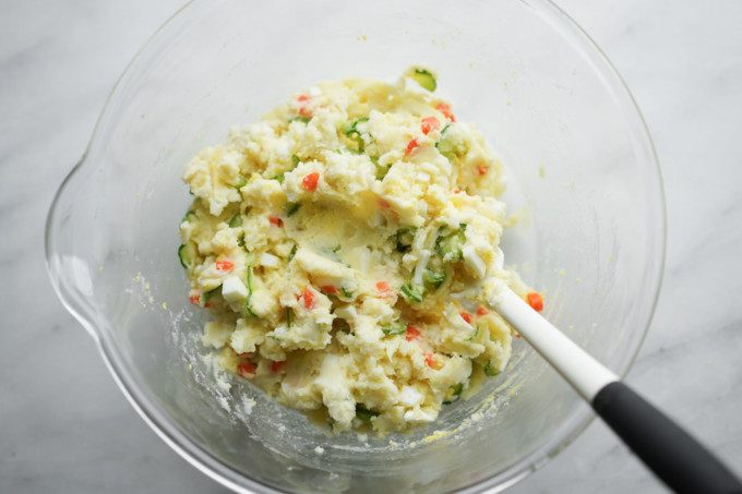 adding veggies to potato salad