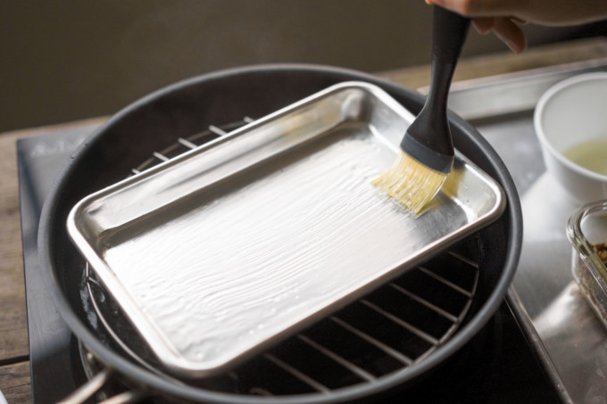 oiling a sheet pan with a brush