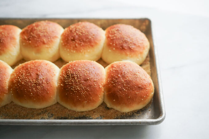 pandesal bread rolls on aluminum sheet