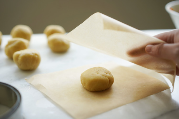 placing dough between parchment paper