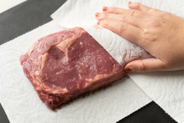 patting steak dry with paper towel
